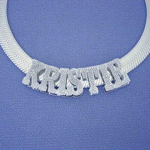 Custom 3D rhodium-plated sterling silver name slider pendant displayed on a blue display background