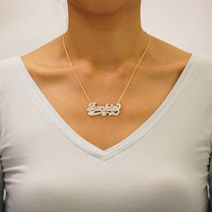 Custom solid gold iced out 3D double plate nameplate necklace worn on a gold chain.