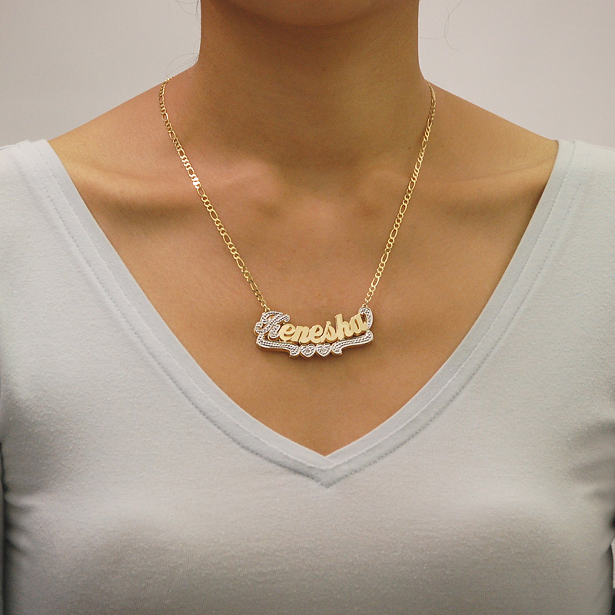 Custom solid gold double plate 3D name pendant shown attached to a gold Figaro chain