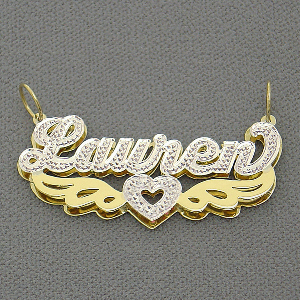 Close up of hand carved iced out white rhodium diamond accents on custom 14k two tone nameplate pendant.