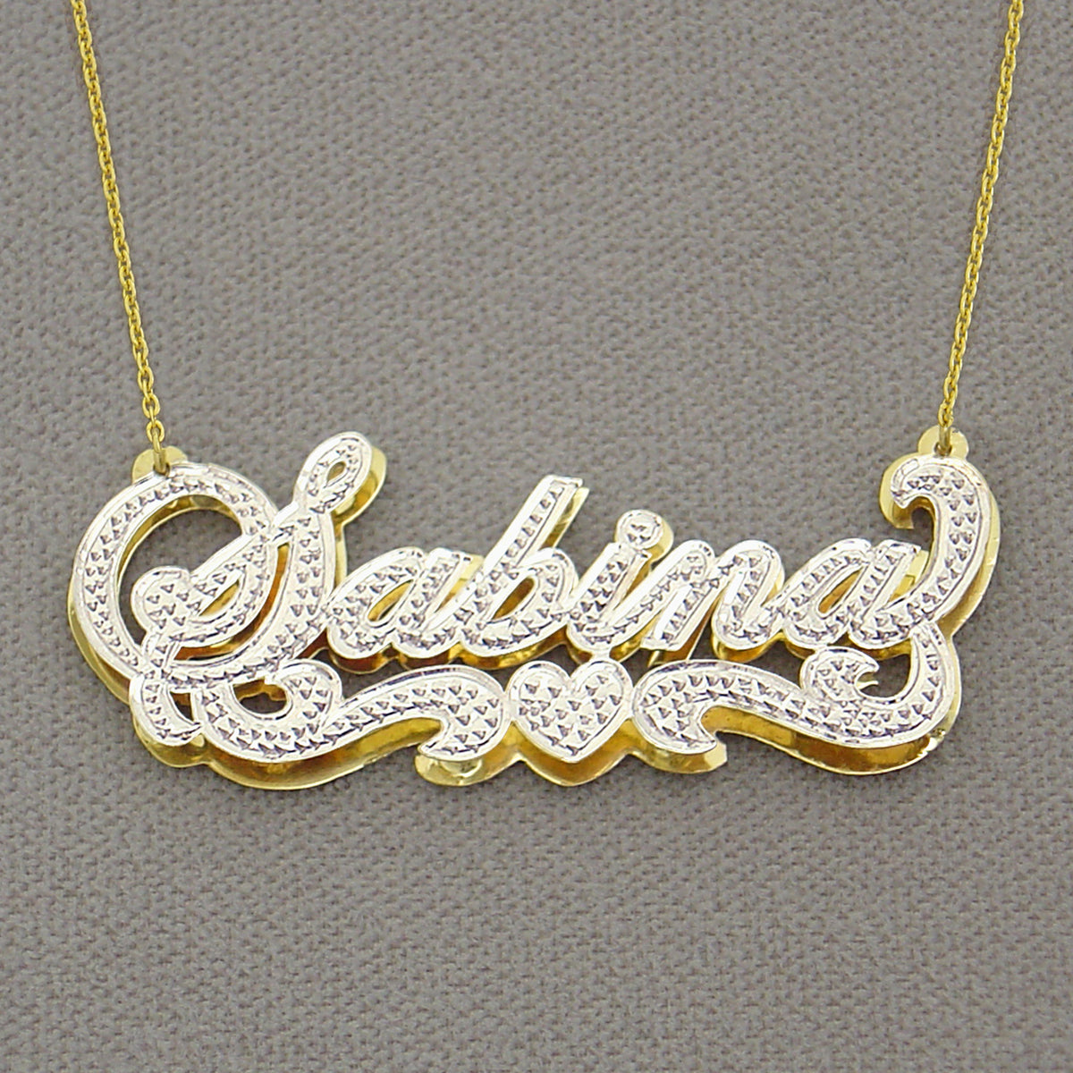 handcrafted 14K gold custom nameplate charm displaying solid backing construction