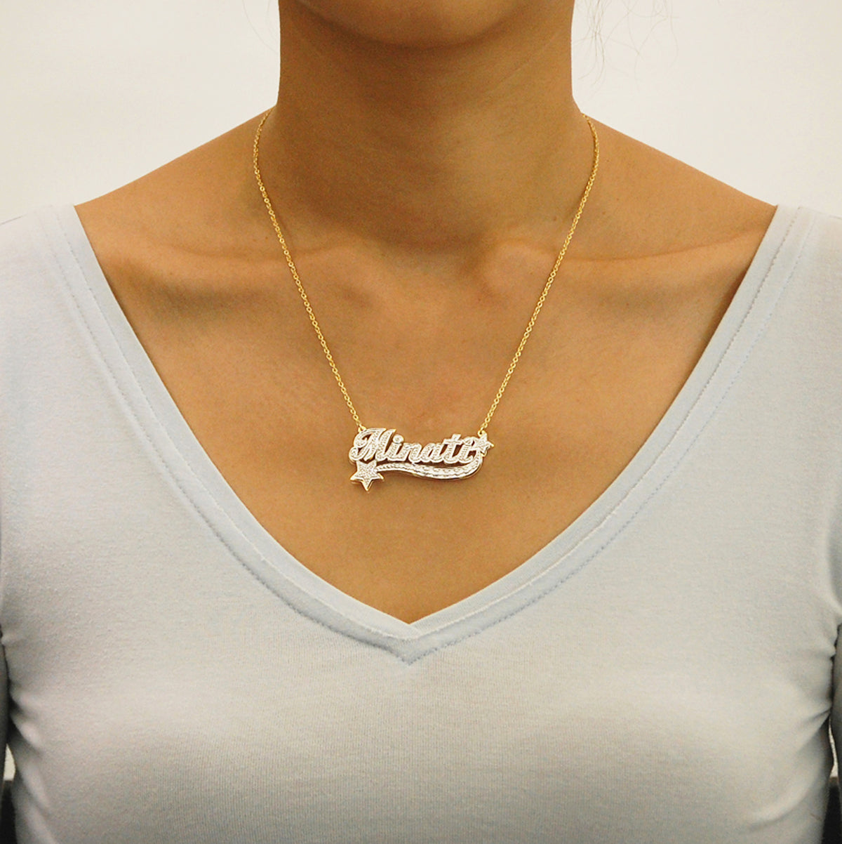 Model wearing custom solid gold 3D star nameplate necklace with a rolo chain.