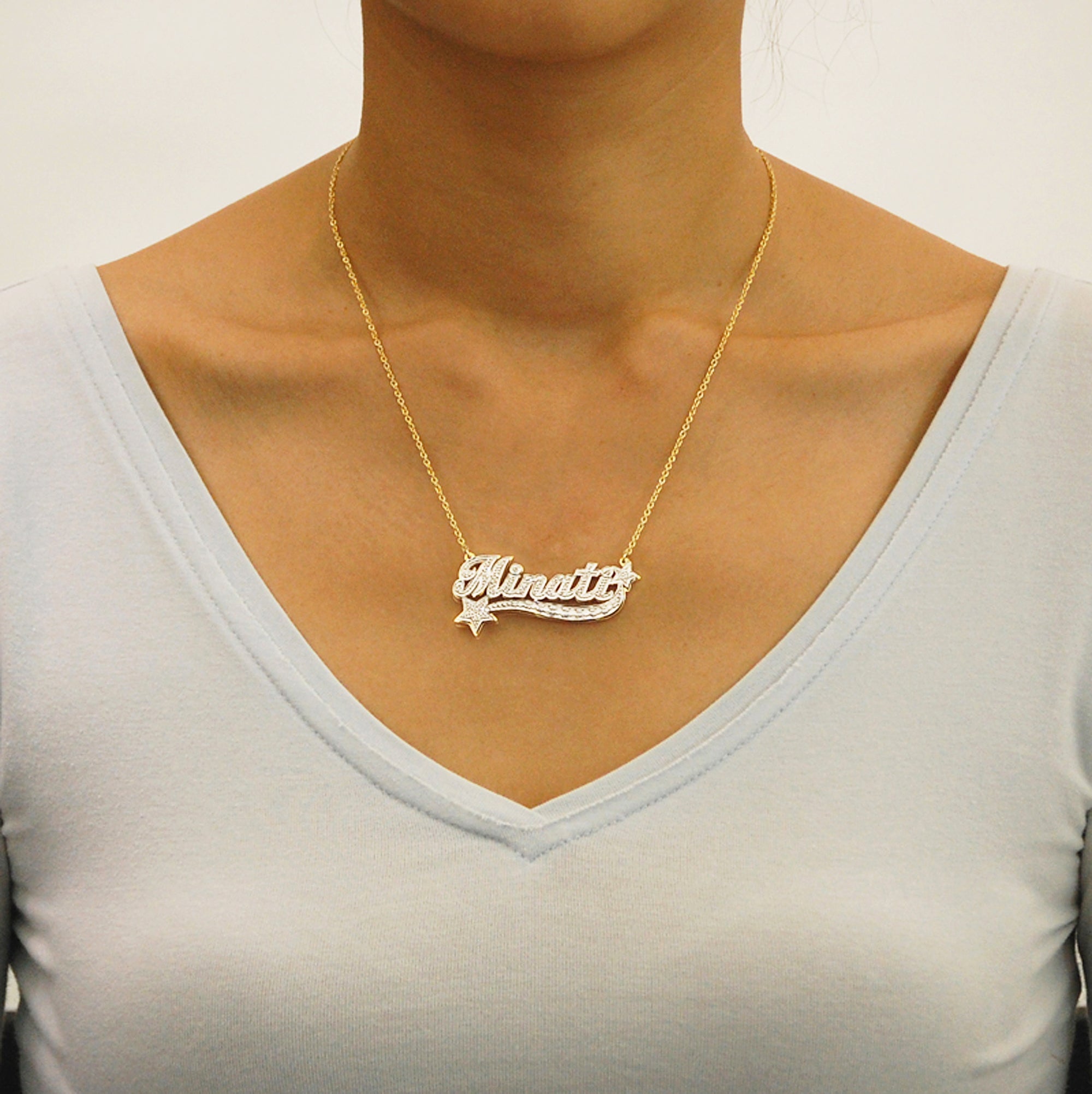 Model wearing custom solid gold 3D star nameplate necklace with a rolo chain.