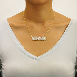 Model wearing a personalized gold 3D double plate nameplate pendant on a solid gold Cuban link chain.