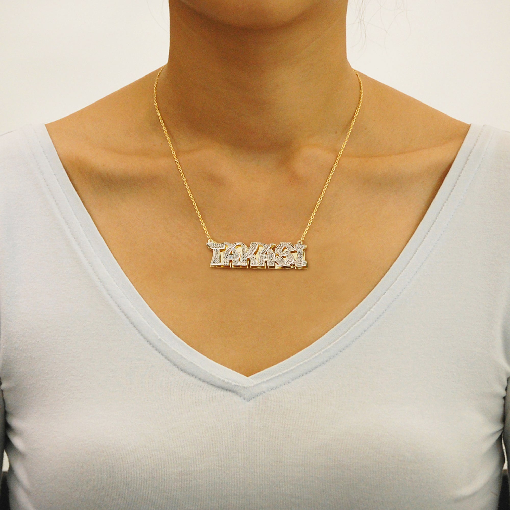 Model wearing a personalized gold 3D double plate nameplate pendant on a solid gold Cuban link chain.