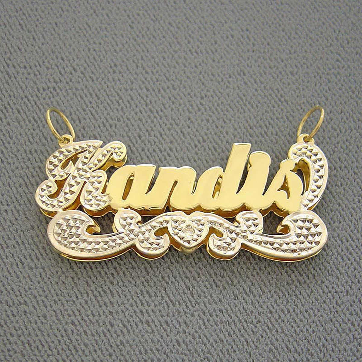 Close-up of hand-carved diamond accent detail and solid 10K or 14K yellow gold backing on custom 3D nameplate charm.