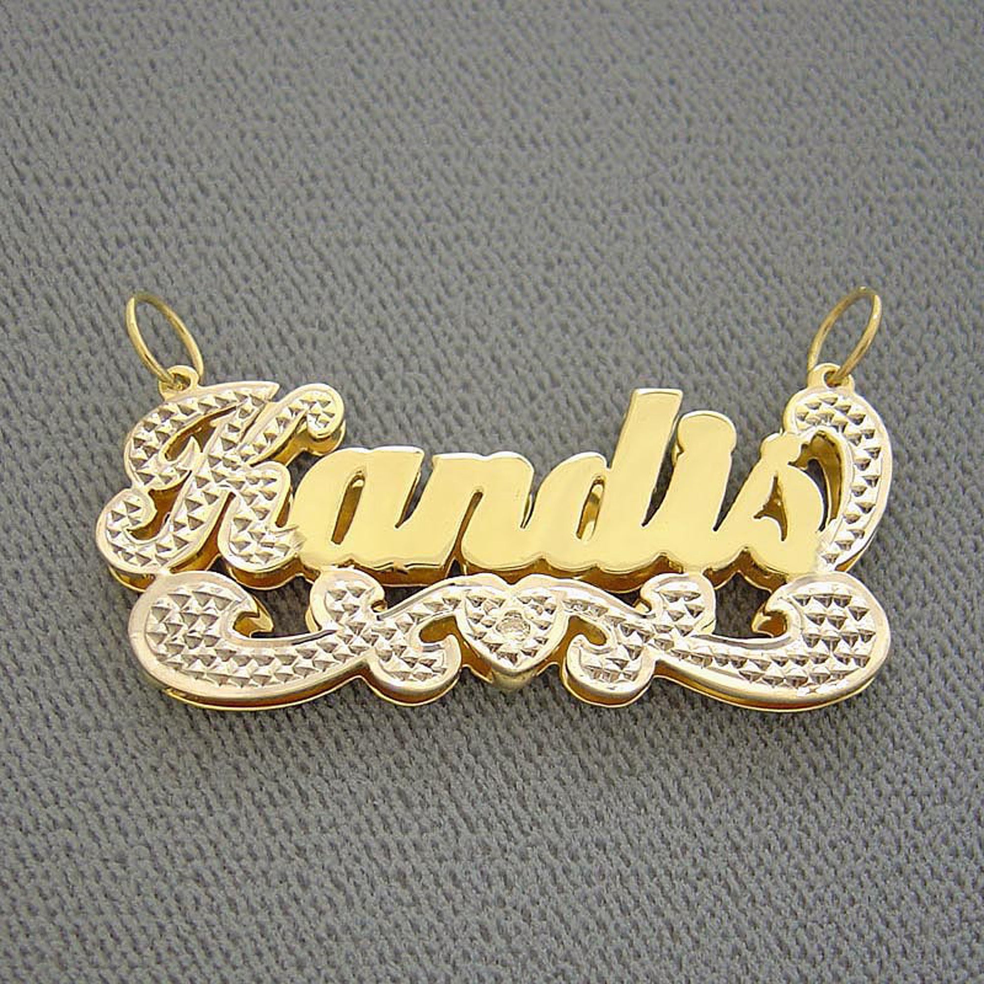 Close-up of hand-carved diamond accent detail and solid 10K or 14K yellow gold backing on custom 3D nameplate charm.