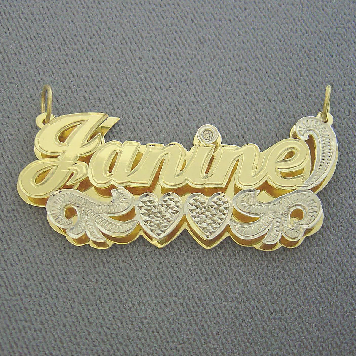 Angled close-up highlighting the diamond-cut rhodium finish and hand-carved bottom plate of the 3D name pendant.