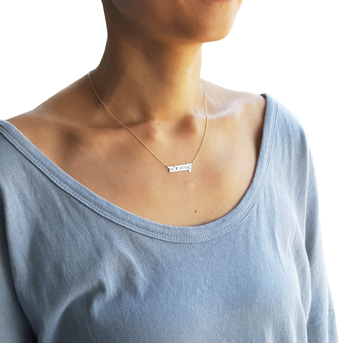 Model wearing a 14k solid gold dainty mommy nameplate necklace at a 16-inch length.