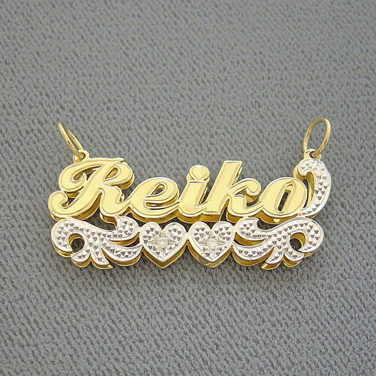 Close-up of solid gold two-tone custom nameplate with white-tone diamond accents.