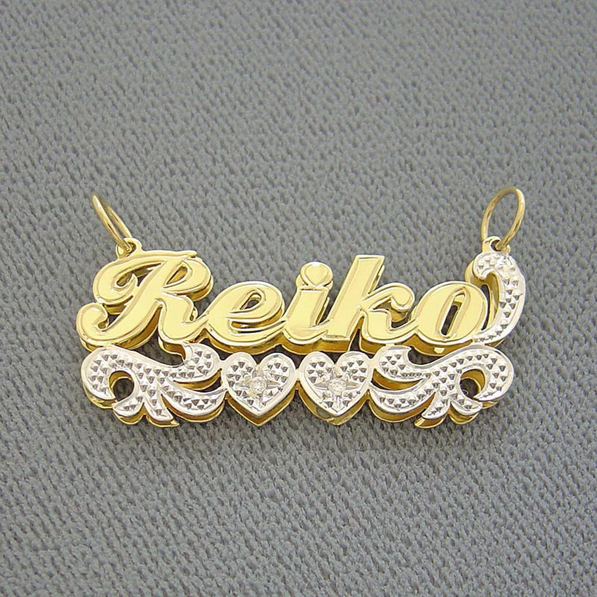 Close-up of solid gold two-tone custom nameplate with white-tone diamond accents.