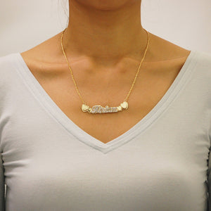Woman wearing custom 14k solid gold double plate name necklace with heart accent