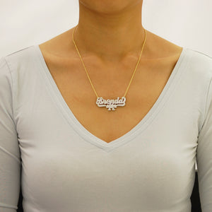 Woman wearing a custom 10k or 14k solid gold personalized 3D nameplate necklace with ribbon charm.
