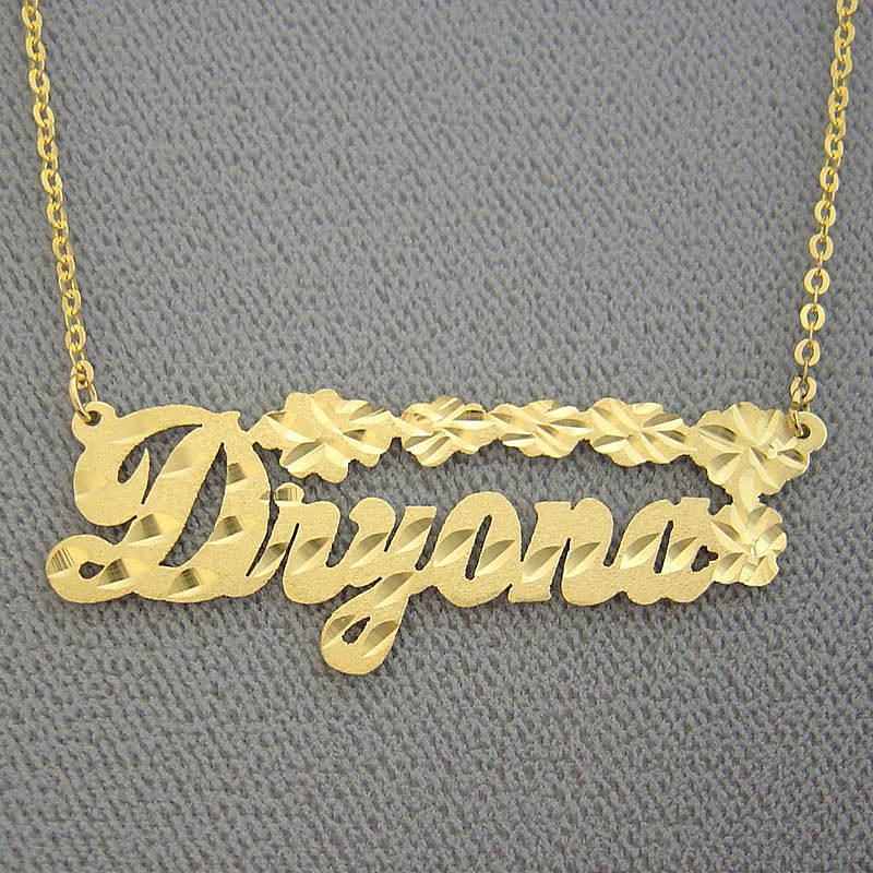 14K solid gold personalized name necklace featuring diamond-cut flower accents, custom made in script cursive for Dryana.