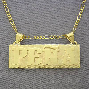 Close-up of custom 14k gold rectangular nameplate showing the 0.7mm raised lettering and 0.5mm base plate thickness.