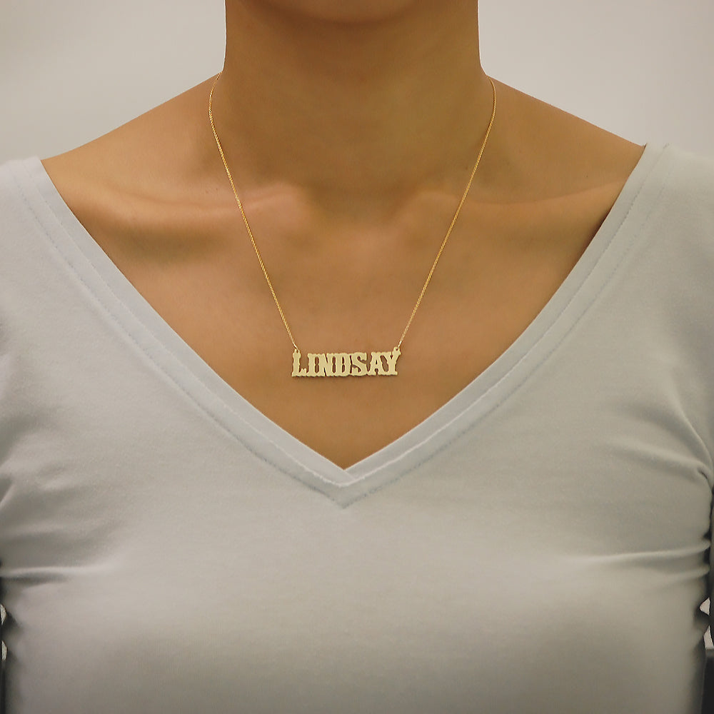 Model wearing personalized 14k gold western style name pendant necklace.