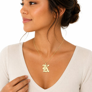 Front view of the 14k gold gothic monogram initial K pendant charm worn on a chain.