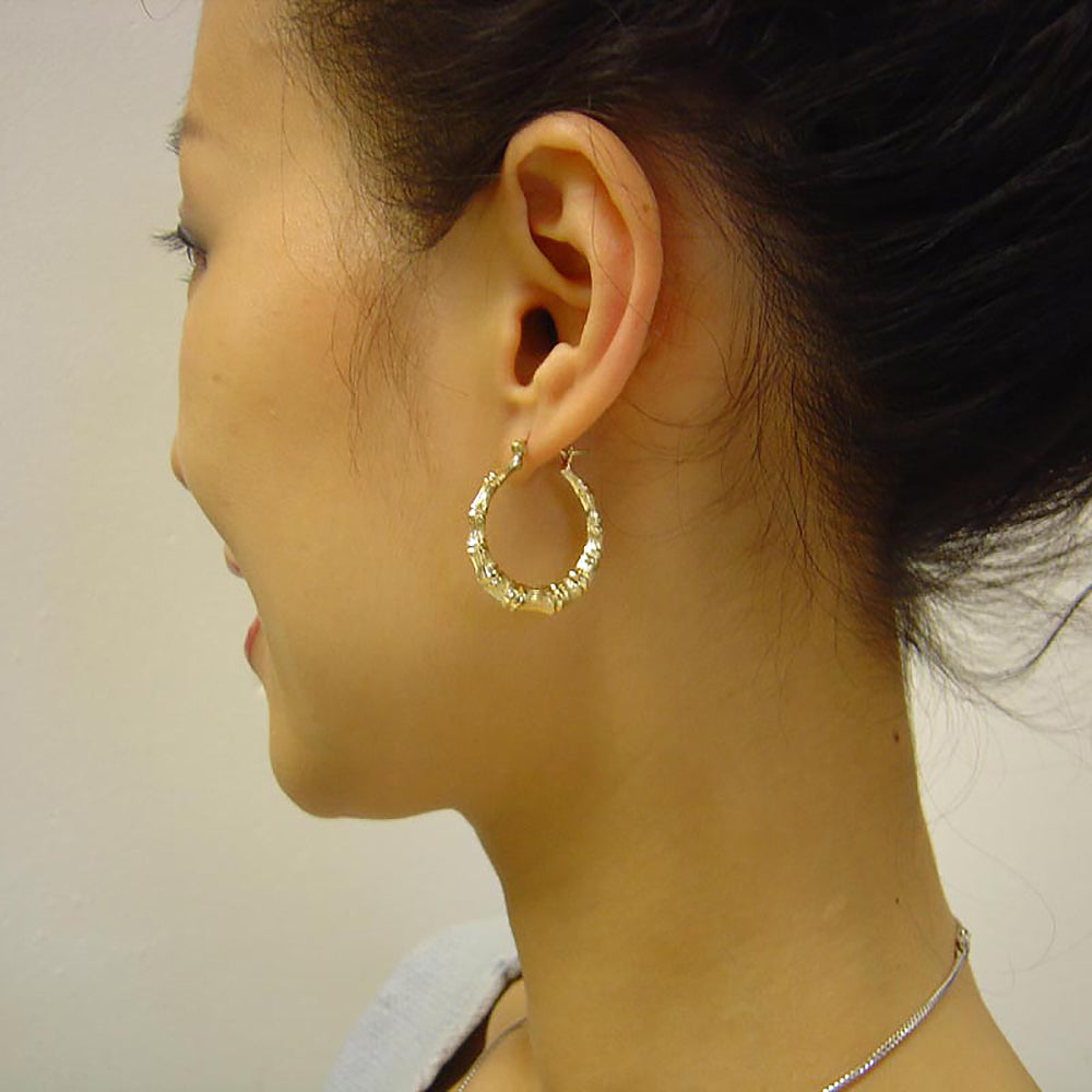 1 inch 10kt gold hollow round bamboo earrings on the model