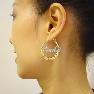 Model wearing 1.3-inch personalized two-tone gold iced out bamboo name hoop earrings