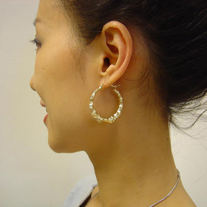 1 3/8 inch gold bamboo hoop earrings on the model