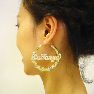 Model wearing 55mm (2 1/8 inch) 10K / 14K real gold custom name bamboo hoop earrings.