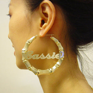 Model wearing large 3-inch 10K gold personalized bamboo name hoop earrings