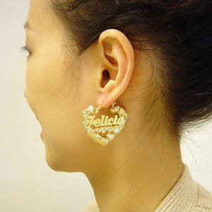 Woman wearing a 1.5-inch custom gold heart bamboo hoop name earring showing scale and fit on the ear