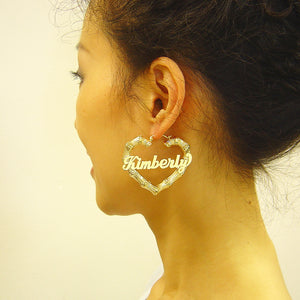 Close-up detail of personalized nameplate on 2 inch gold heart bamboo hoop earrings