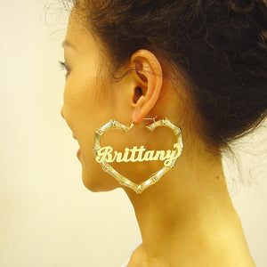 Model wearing large personalized real gold heart bamboo nameplate earrings.