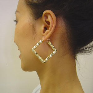 Model wearing 2 inch 10K gold square puffed bamboo door knocker hoop earrings