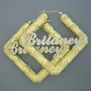 Detail view of custom 2-tone iced out cursive nameplate on 10k gold square bamboo earring