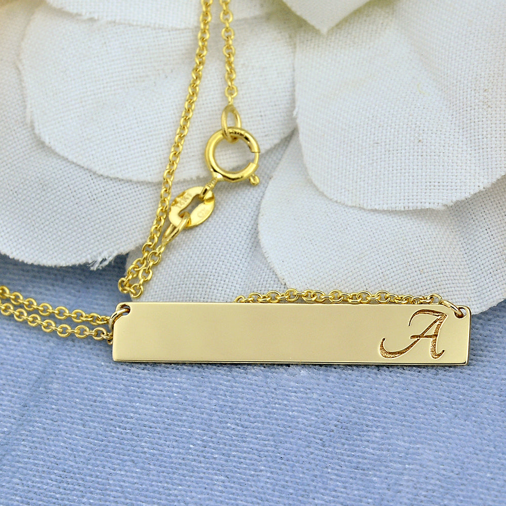 Close-up of high-polish 10k solid white gold bar pendant with clear laser engraving