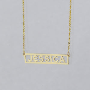 A gold nameplate necklace spelling 'JESSICA' in a horizontal bar cutout design.