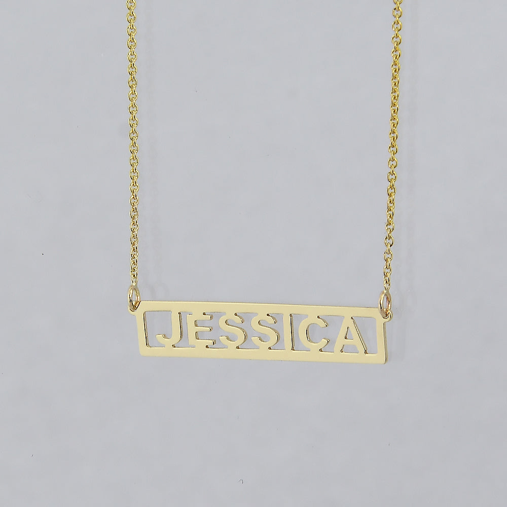 A gold nameplate necklace spelling 'JESSICA' in a horizontal bar cutout design.