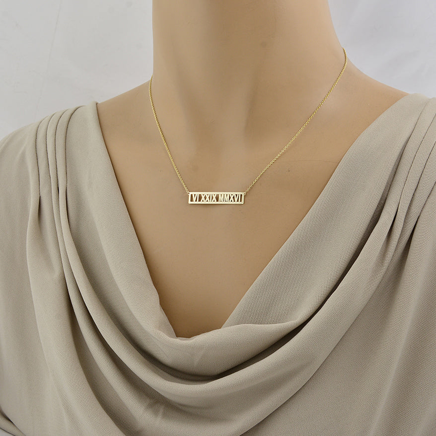mannequin wearing personalized 14k yellow gold Roman numeral bar necklace on split Rolo chain