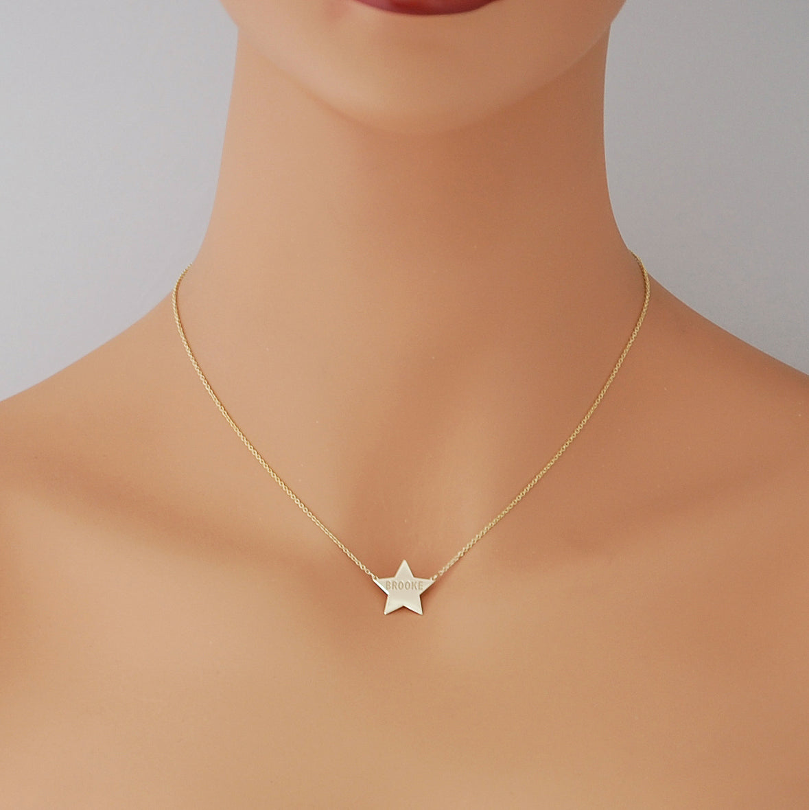 mannequin wearing custom solid gold star pendant necklace with laser