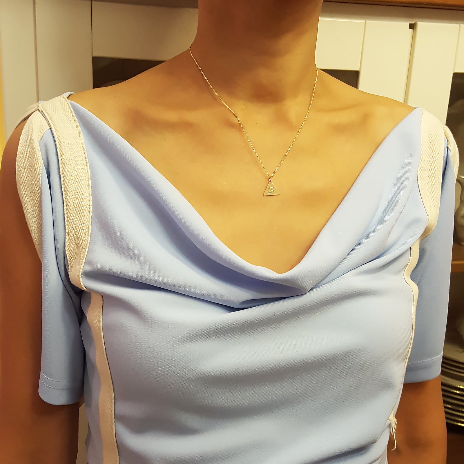 Model wearing dainty solid gold triangle initial pendant necklace
