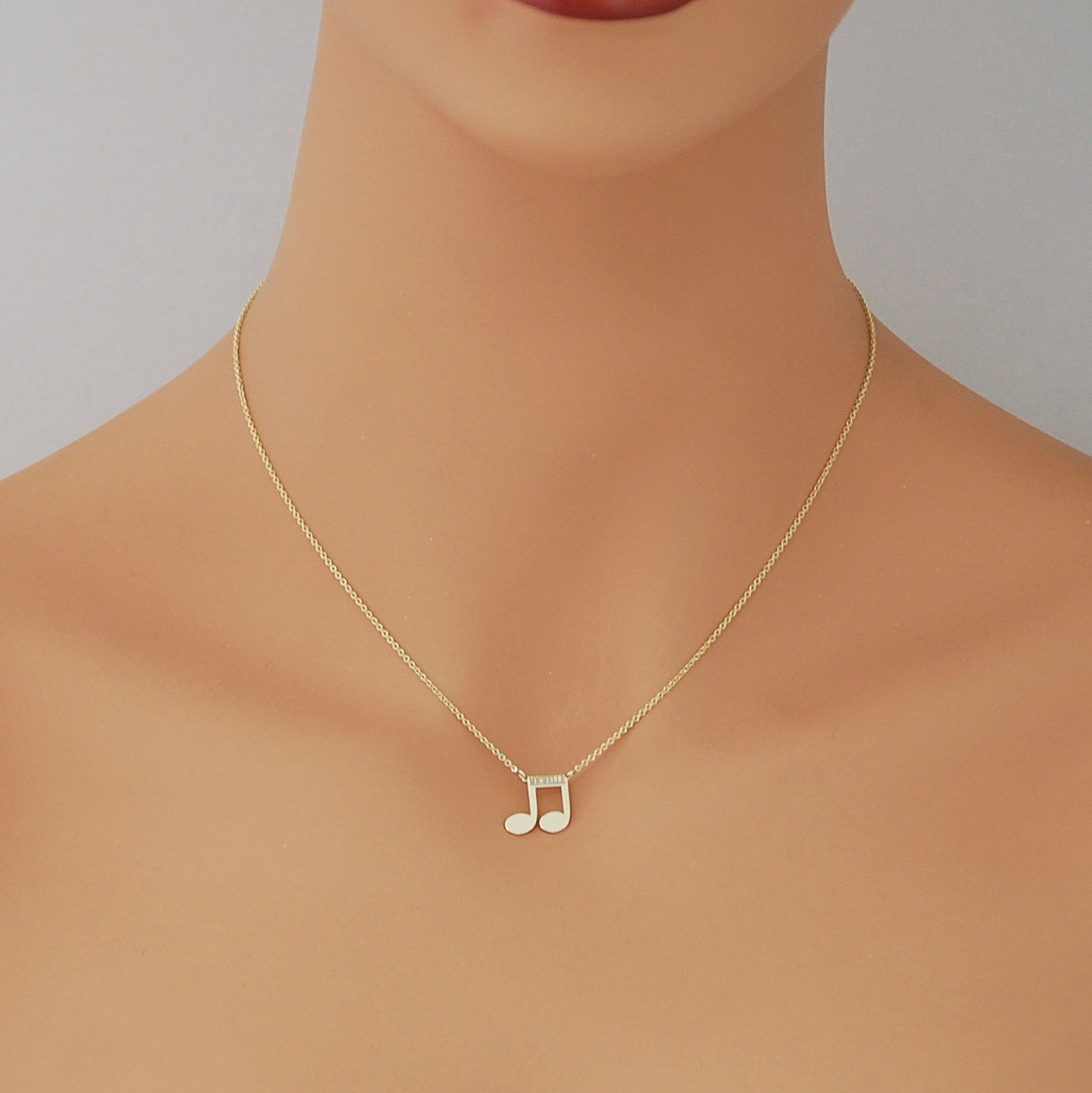 mannequin wearing personalized solid gold music note pendant necklace