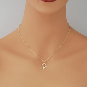 A delicate gold chain necklace with a small musical note pendant displayed on a mannequin