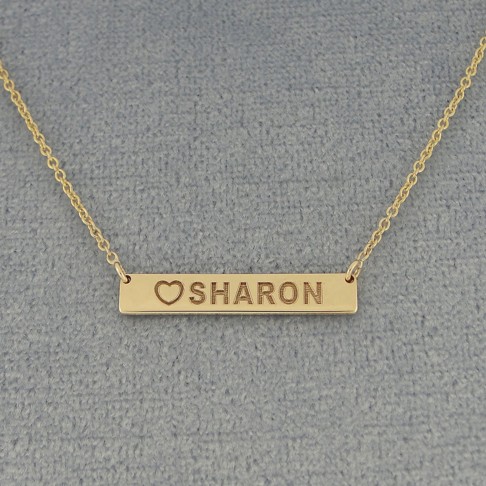 Close-up of solid gold personalized heart name bar pendant