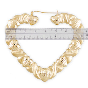 Front view of 10k yellow gold hollow XO heart hoop earrings with diamond-cut pattern and snap closure