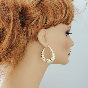Side view of lightweight hollow 10K gold oval shrimp hoop earrings
