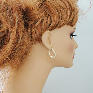 Hinged snap closure detail on 10k gold baby shrimp hoop earrings