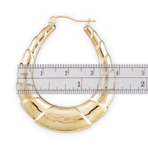 Ruler measuring 1.5 inch width of 10k gold shrimp door knocker oval earrings