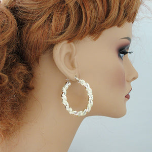 1.5 inch wide 10K gold twisted oval door knocker earrings on mannequin.