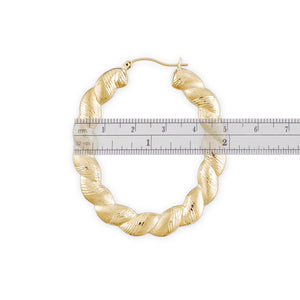 Close-up detail of 10K gold twisted diamond-cut pattern on oval door knocker earring