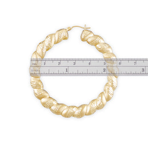 Close-up of 10k gold twisted puffy door knocker earring showing diamond-cut texture and snap closure