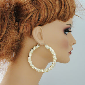 wearing oversized 2.9 inch 10k gold twisted door knocker hoop earrings