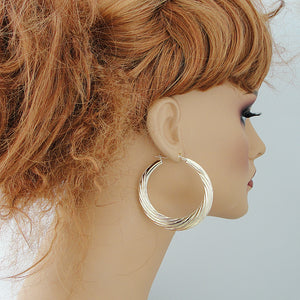 wearing 10K solid yellow gold 2.25 inch swirl door knocker earrings