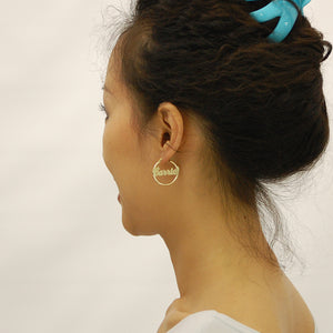 Model wearing 1-inch 14K yellow gold custom name hoop earrings